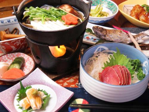 a table with bowls of food and a pot of soup at Oyado Ichifuji in Nikko