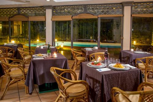 a dining room with tables and chairs and a pool at Best Western Park Hotel Roma Nord in Fiano Romano
