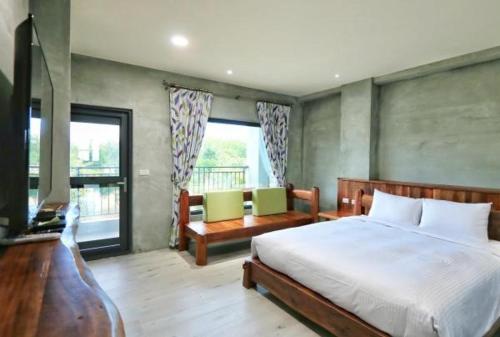 a bedroom with a large bed and a balcony at 里夏民宿.墾丁後壁湖 in Hengchun