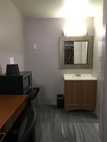 a bathroom with a sink and a mirror on the wall at Budget Inn & Suites in Amarillo
