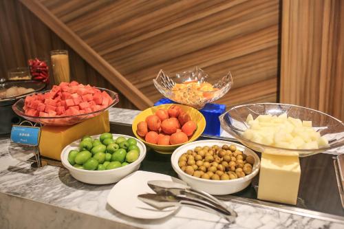 a buffet with bowls of fruits and vegetables on a table at Skytel Hotel Chengdu-City Center in Chengdu