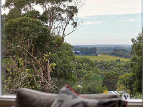 
a pair of shoes sits on a ledge overlooking a forest at Myers Road Retreat Plus Guest House in Merricks North
