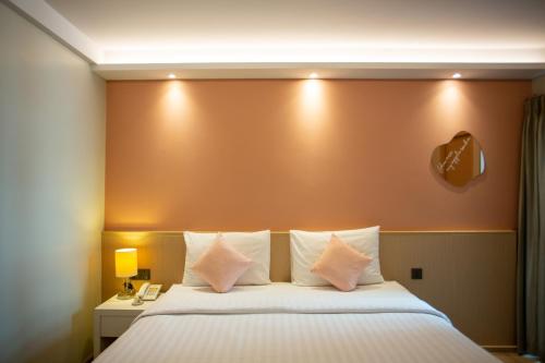 a hotel room with a large bed with white pillows at Lemontea Hotel Bangkok in Bangkok