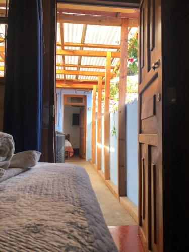 a bedroom with a bed and an open door at Dionisio Inn in Antigua Guatemala