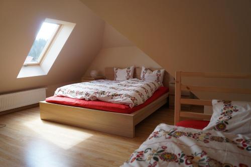 1 dormitorio en el ático con 2 camas y ventana en Misiówka, en Szklarska Poręba