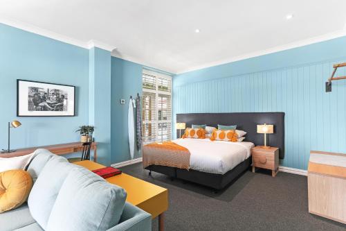 Habitación de hotel con cama y sofá en Coogee Bay Hotel en Sídney