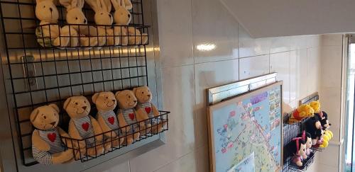 a wall with a rack of teddy bears with a board at Naksanstay in Yangyang