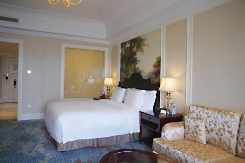 a bedroom with a large white bed and a couch at Crowne Plaza Ocean Spring Resort by IHG in Jimo