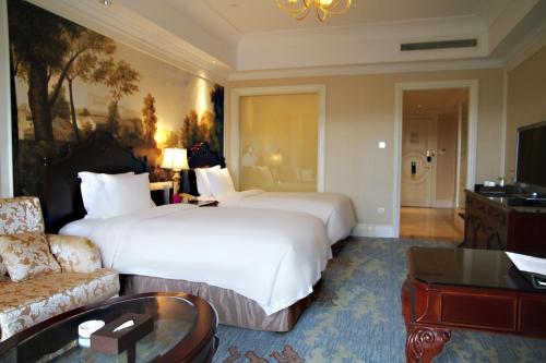 a hotel room with a large bed and a couch at Crowne Plaza Ocean Spring Resort by IHG in Jimo