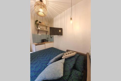 Un dormitorio con una cama con un edredón azul. en Home Sweet Home Pigalle Montmartre Jungle, en París