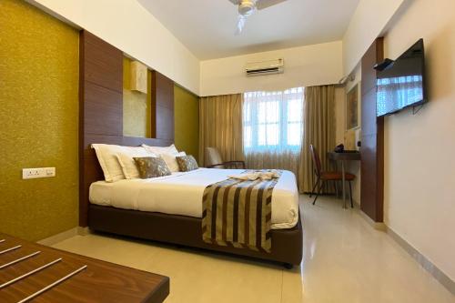 a hotel room with a bed and a television at Hotel Park Plaza in Panaji