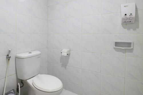 a bathroom with a toilet and a white tiled wall at Narima Resort Hotel in Lembang