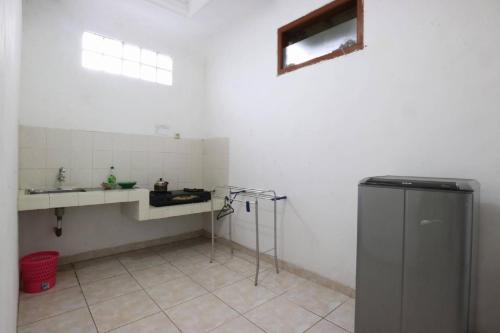 uma pequena cozinha branca com um lavatório e um frigorífico em Narima Resort Hotel em Lembang