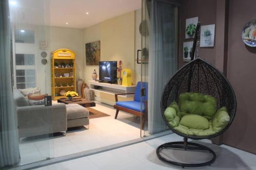 a living room with a green chair in a living room at Holiday Home Bogor Syariah in Bogor