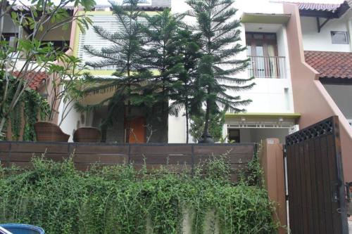 a fence in front of a house with a tree at Holiday Home Bogor Syariah in Bogor