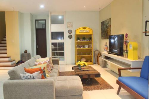 a living room with a couch and a tv at Holiday Home Bogor Syariah in Bogor