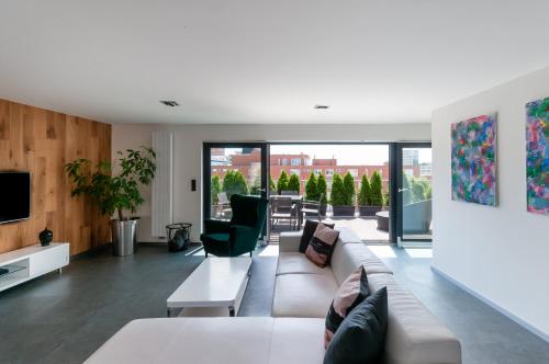 a living room with a couch and a tv at VV hotel & apartments in Brno