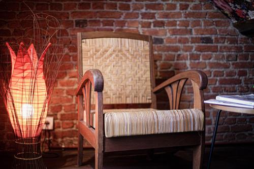 a chair and a lamp next to a brick wall at Luxury Suites Historic Center by Rikas Hotels in Antwerp