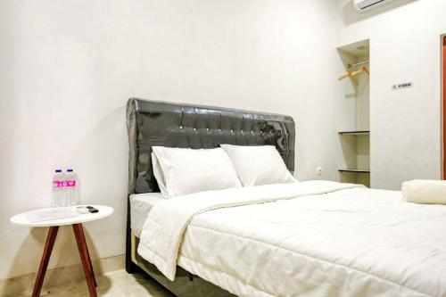 Schlafzimmer mit einem Bett und einem Beistelltisch in der Unterkunft Rudi Rooms near Stasiun Cikarang Mitra RedDoorz in Jakarta