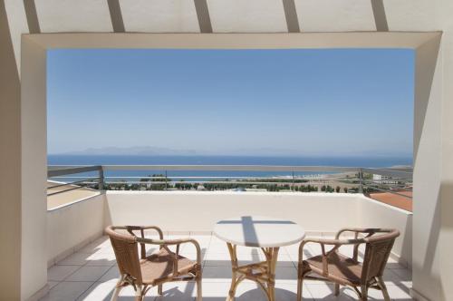 a balcony with a table and chairs and a view of the ocean at Kipriotis Panorama Hotel & Suites in Kos Town