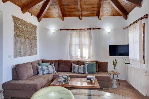 - un salon avec un canapé brun et une table dans l'établissement Panorama Villas, à Drymon