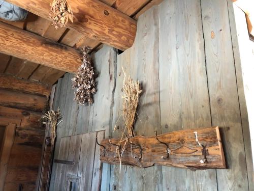 a room with a wooden wall with some branches on it at Viesu nams Vālodzes in Sigulda