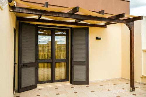 a pergola over a door on a house at Olimpo B&B in Giurdignano