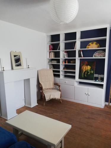 - un salon avec une armoire blanche et une table dans l'établissement L'élie sous les noyers, Le gite, à Clérieux