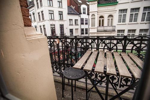 a wooden bench sitting on top of a balcony at Luxury Suites Historic Center by Rikas Hotels in Antwerp