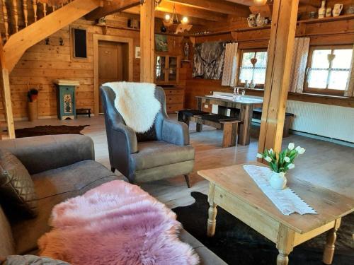 una sala de estar con sofás y una mesa en una cabaña en Chalet Waldstadl, Andrea's Woidhaisl en Arnbruck