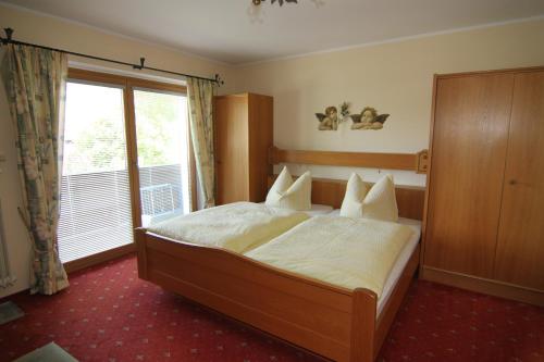 a bedroom with a bed and a large window at Ferienwohnungen Bodnereck in Schönau am Königssee