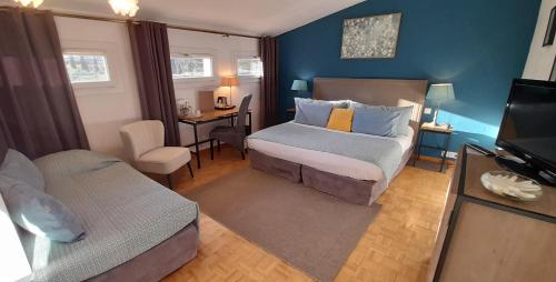 レ・ボー・ド・プロヴァンスにあるLogis Hôtel Fabian des Bauxのベッドとソファとテレビのある寝室