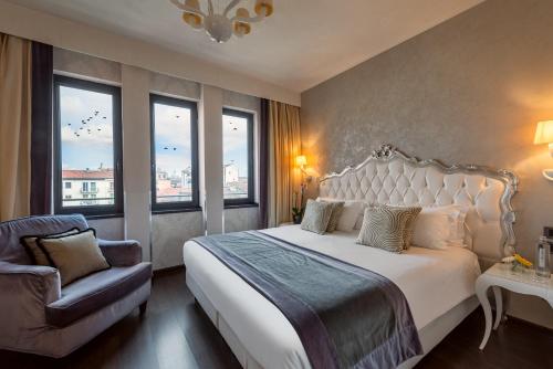a bedroom with a bed and a chair and windows at Carnival Palace - Venice Collection in Venice