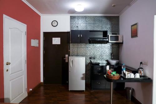 a kitchen with a refrigerator and a table in it at Royal Orchid Golden Suites Pune in Pune