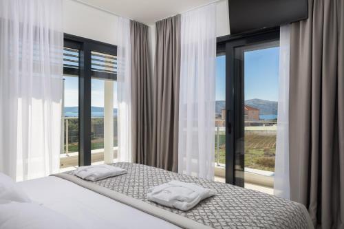 a bedroom with a bed with two white towels on it at Villas Baotić in Seget Vranjica