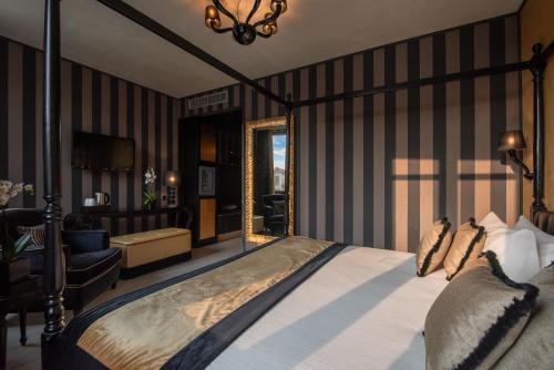 a bedroom with a bed and a chair and a mirror at Carnival Palace - Venice Collection in Venice