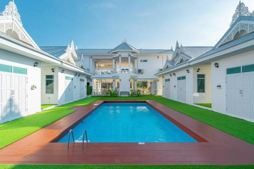 a large house with a swimming pool in the yard at Bianco House Resort in Cha Am