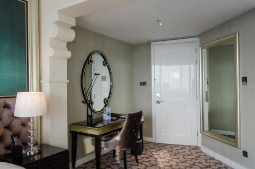 a room with a mirror and a desk with a chair at Hotel Ciputra World Surabaya managed by Swiss-Belhotel International in Surabaya