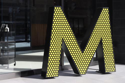 a large sign with yellow polka dots in front of a building at Hotel The M's Kyoto in Kyoto