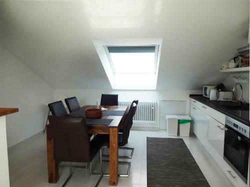 a kitchen with a dining room table and a skylight at Moderne Wohnungen am Bahnhof Dachau mit direkter S-Bahn Verbindung nach München in Dachau