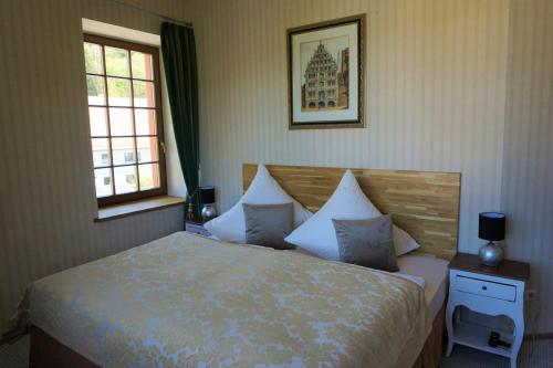 a bedroom with a bed with white sheets and pillows at Hotel Schlossresidenz Heitzenhofen in Duggendorf
