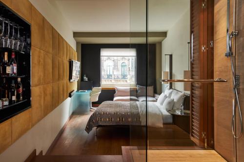 a hotel room with a bed and a glass wall at DO&CO Hotel Vienna in Vienna