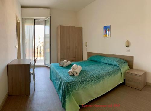 een slaapkamer met een bed met twee handdoeken erop bij Hotel Ritter in Cattolica