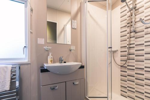 uma casa de banho com um lavatório e um chuveiro em Hidden Jewel Lodge with Hot Tub em York