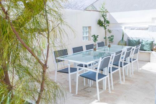 a table and chairs on a patio with trees at La Maison de Famille 3 chambres 8 pers Terrasse Parking Clim in Marseille