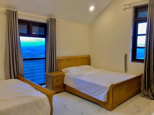 1 dormitorio con 2 camas y ventana grande en Cánh Đồng Mây Homestay Đà Lạt en Ấp Ða Lôc
