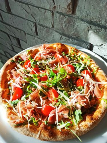 a pizza sitting on a plate on a table at Route One - Restauracja & Pokoje Hotelowe in Zgierz