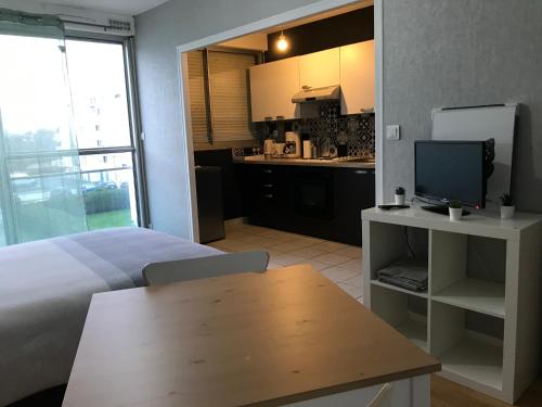 une chambre avec un lit et un bureau avec une télévision dans l'établissement Cosylocation La Varende 38, à Rennes