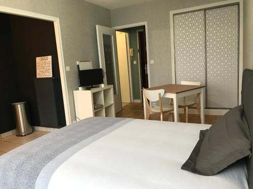 une chambre avec un lit, une table et une télévision dans l'établissement Cosylocation La Varende 38, à Rennes