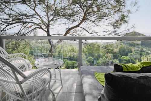 a balcony with a couch and chairs and a table at ROBINSON SARIGERME PARK - All Inclusive in Dalaman